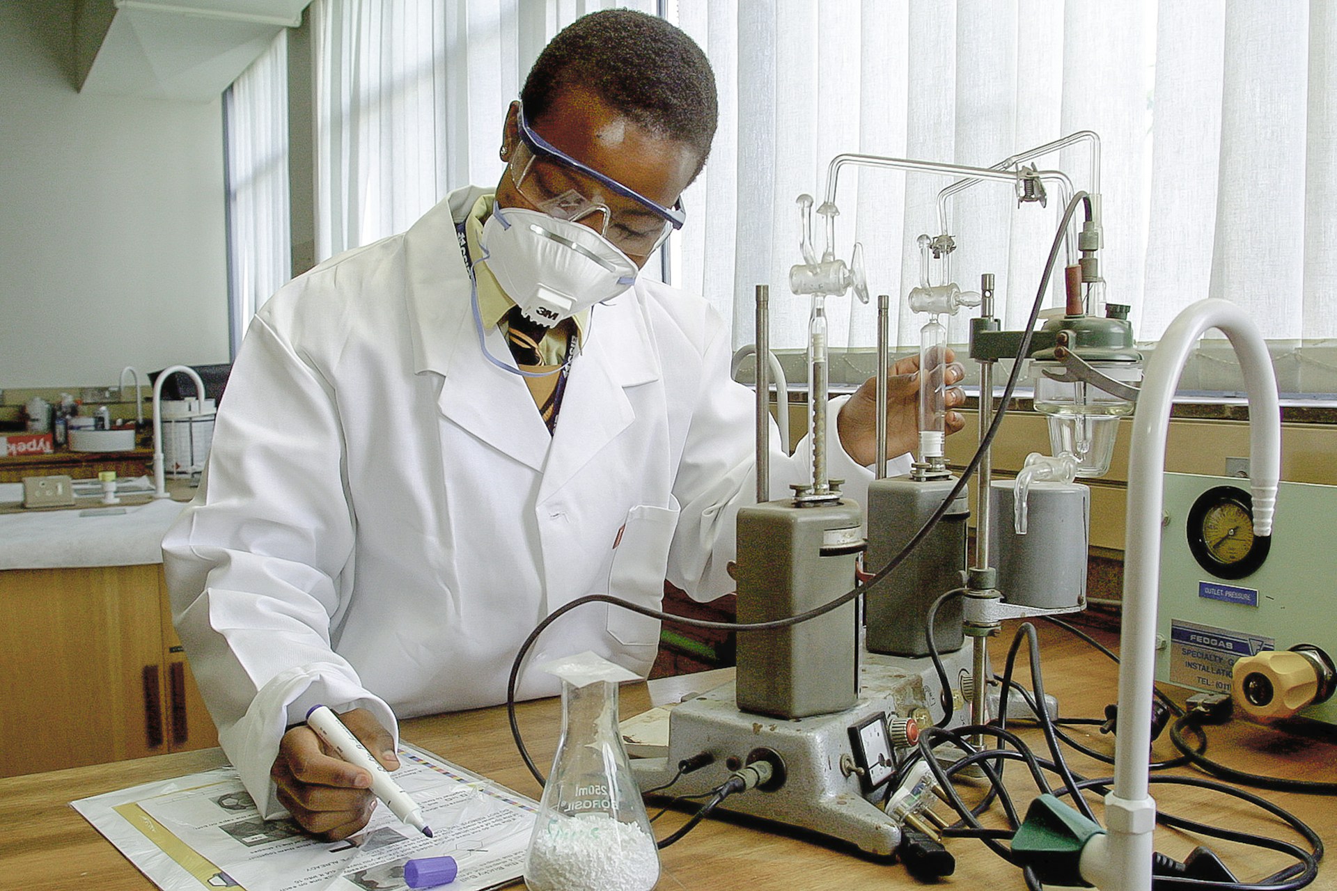 African researcher recording laboratory experiment notes
