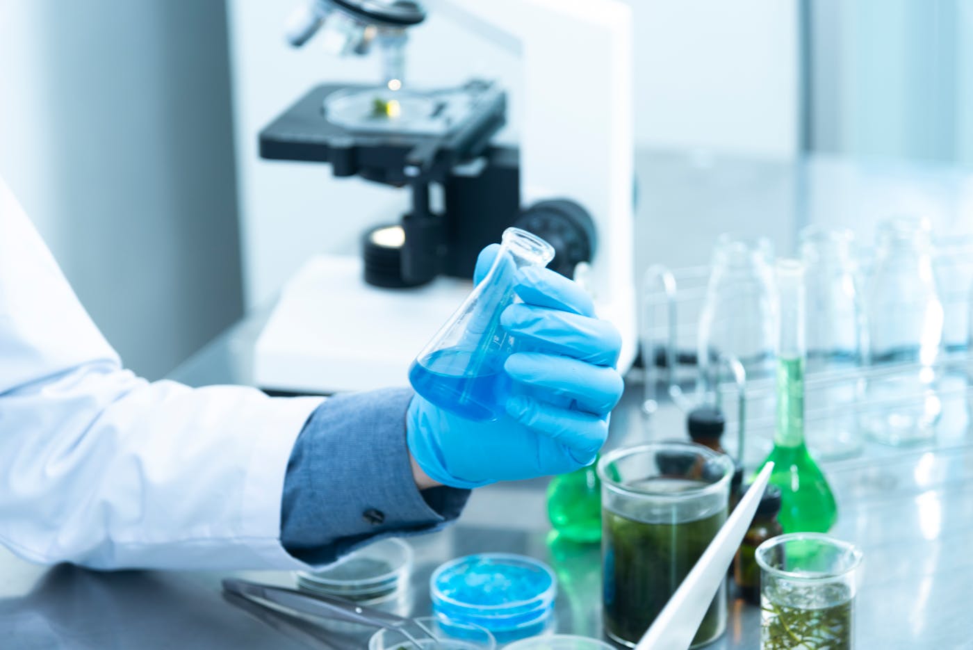 Scientist using microscope and glassware in a research laboratory